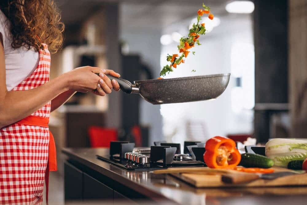 woman cooking vegetables in a stir fry pan with kratom