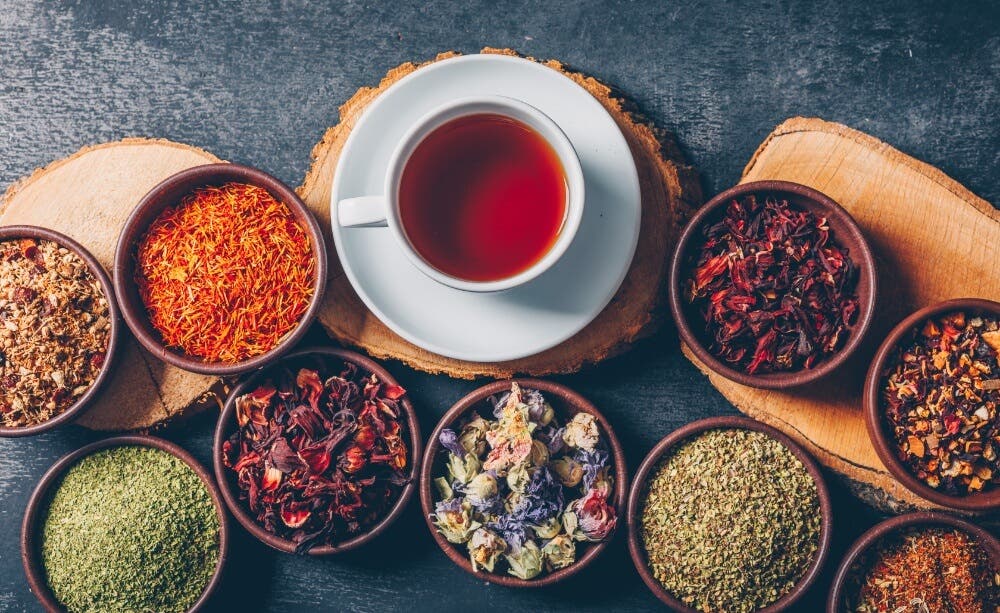 Tea with different herbs around, making kratom tea